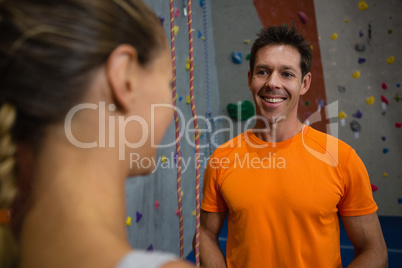 Smiling trainer talking to female athlete at health club