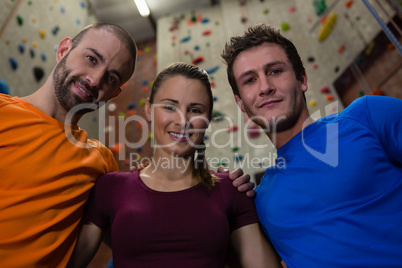 Portrait of confident male trainer with athletes in health club
