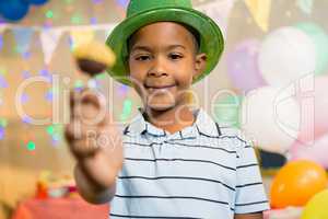 Portrait of happy boy holding lollipop during birthday party