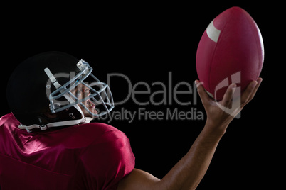 American football player holding a ball in one hand