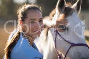 Portrait of smiling female vet checking horse