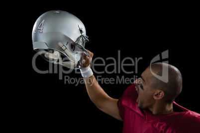 Energetic American football player holding a head gear raised