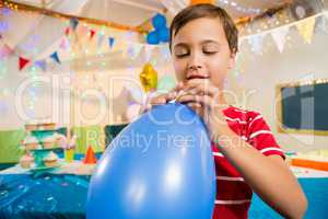 Cute boy holding blue balloon during birthday party
