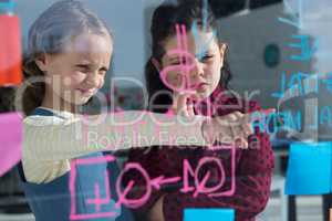 Female colleagues anlayzing data at seen through glass