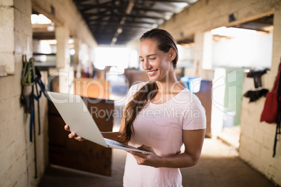 Smiling female jockey using laptop