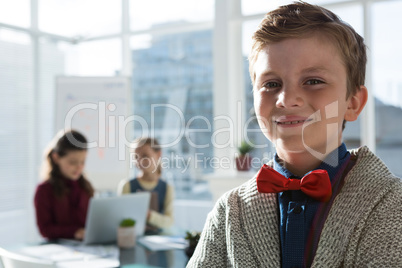 Portrait of smiling businessman with female coworkers in background