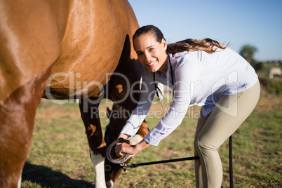 Smiling vet examining horseshoe at barn