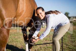 Smiling vet examining horseshoe at barn