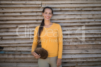 Happy young jockey standing by wall