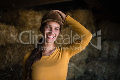 Portrait of happy female jockey in stable