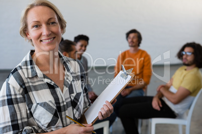 Portrait of smiling teacher with students in background