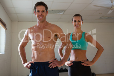 Portrait of fit athletes with hands on hip at fitness club