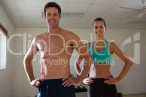 Portrait of fit athletes with hands on hip at fitness club