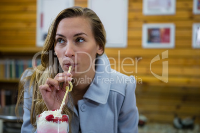 Woman looking away while having drink in cafe