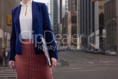 Business woman holding a folder against city background