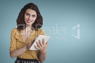 Happy business woman using a tablet against blue background