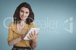 Happy business woman using a tablet against blue background