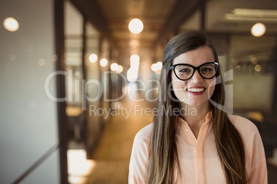 Happy business woman standing against office background