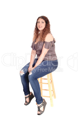 Young woman sitting on a bar chair, smiling