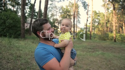 Father picking up toddler son from baby carriage