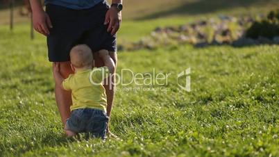 Infant child trying to stand up with father's help