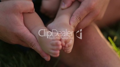 Tiny baby feet in caring father's hands