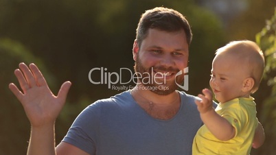 Portrait of happy father and infant son outdoors