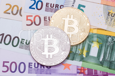 Golden and silver bitcoins on US dollars and euro. Electronic mo