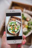 Smartphone macht Foto von Sommer Salat