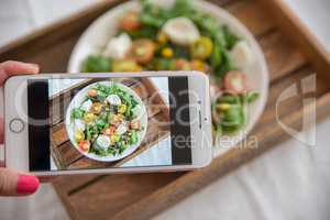 Smartphone macht Foto von Sommer Salat