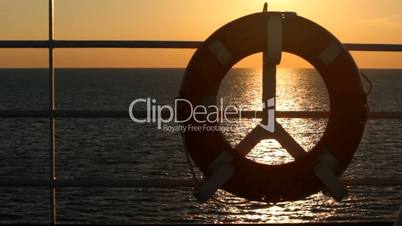 Lifebuoy on a boat crossing the sea at sunset