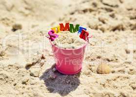 Pink metal baby bucket with sand