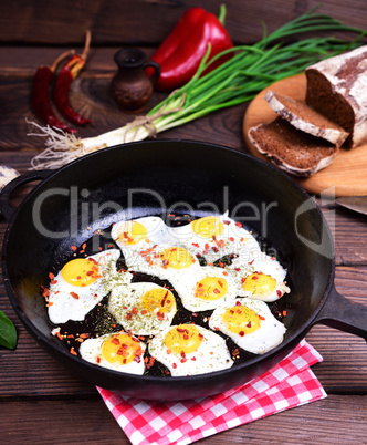 Fried eggs in a black cast-iron frying pan