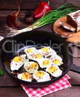 Fried eggs in a black cast-iron frying pan