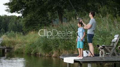 Hipster dad and boy enjoying fishing at the pond