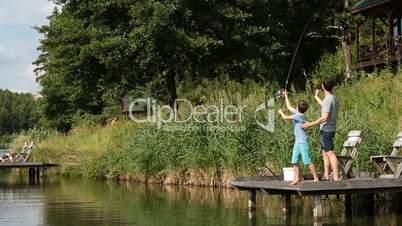 Cute teenager learning to fish on lake in summer