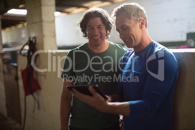 Two male friends using digital tablet