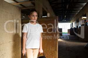 Girl standing in stable