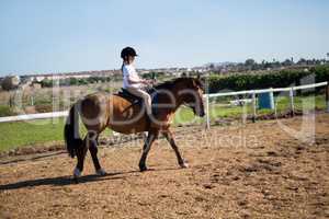 Girl riding a horse in the ranch