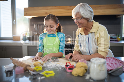 Grandmother and granddaughter cutting dough with a cookie cutter