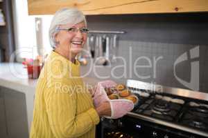 Smiling senior women holding freshly baked muffins