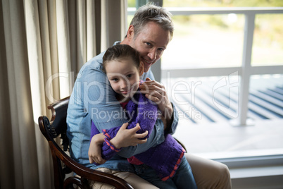 Father and daughter embracing each other in living room