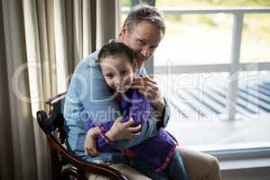 Father and daughter embracing each other in living room