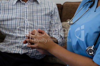 Female doctor consoling senior man in nursing home