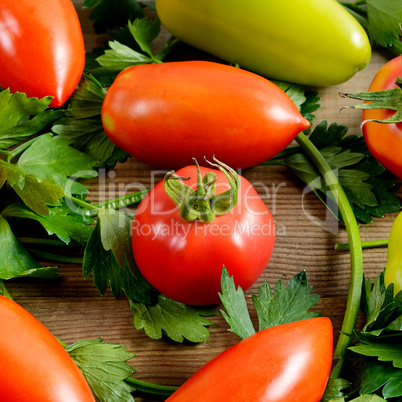 Tomatoes and celery on wooden background.