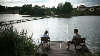 Father and son spending leisure fishing at pond