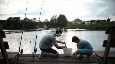 Carefree dad and son preparing to fish on the lake