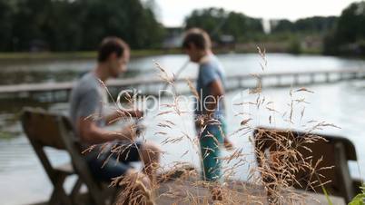 Father teaching son angling with rod at pond