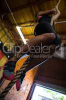Woman practicing rope climbing in fitness studio