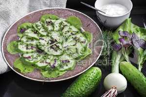 Salad from fresh cucumbers and greens.